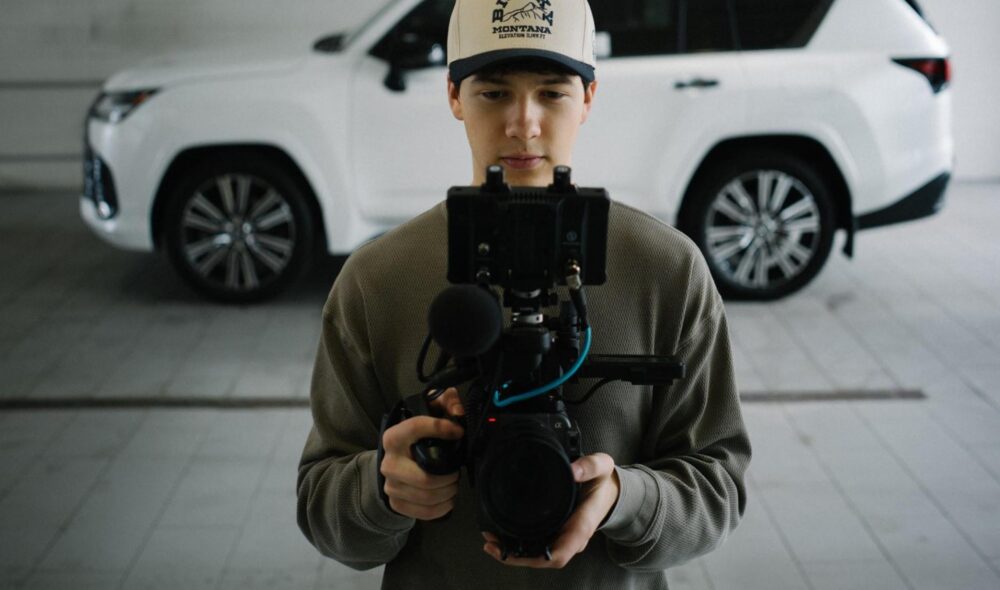 Person filming in car dealership garage