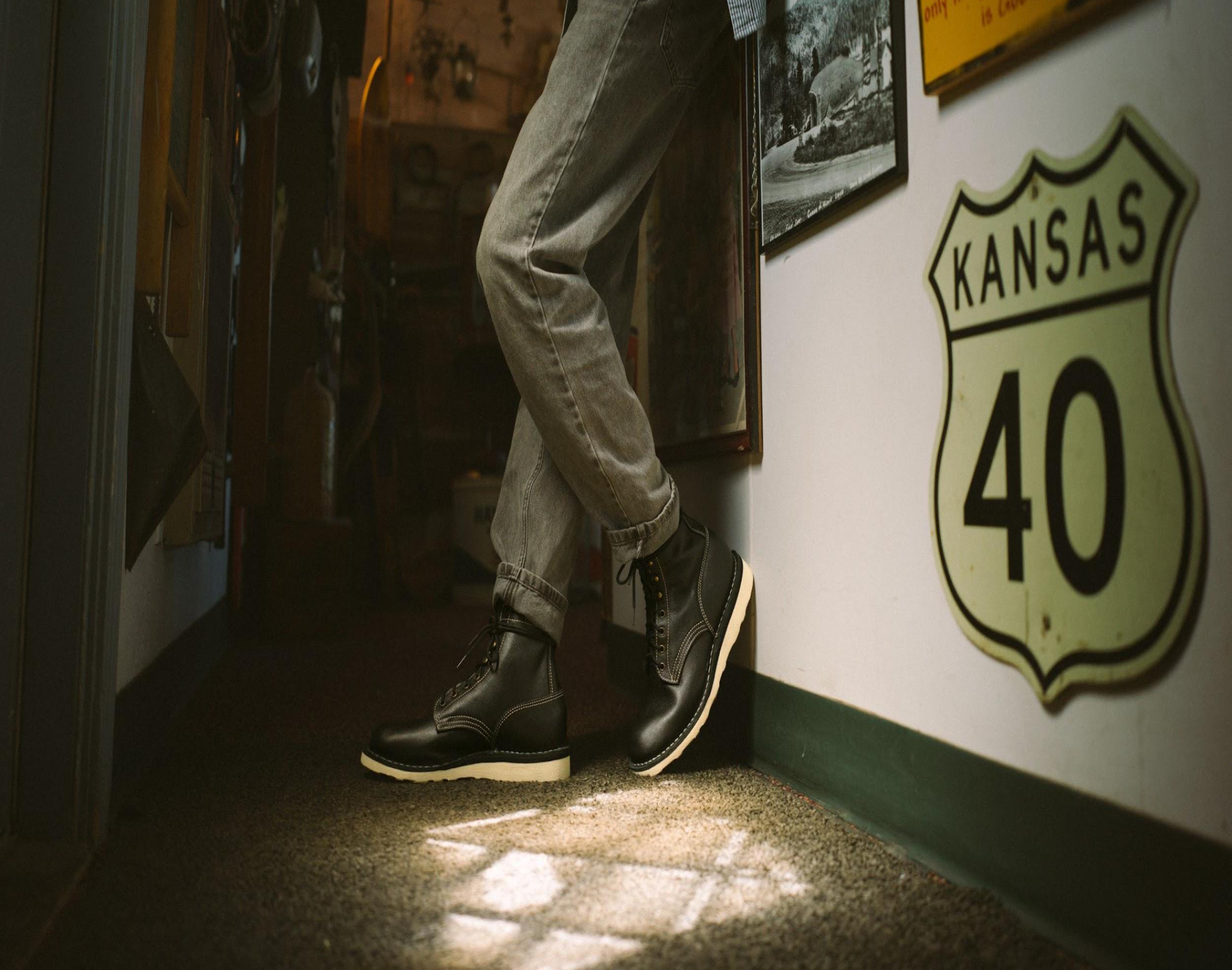 Person wearing black boots indoors.